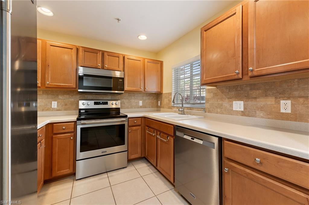 12010 Rock Brook Run, Unit 1704 Fort Myers, FL 33913 - Photo 2 of 17 a kitchen with stainless steel appliances a stove sink and microwave