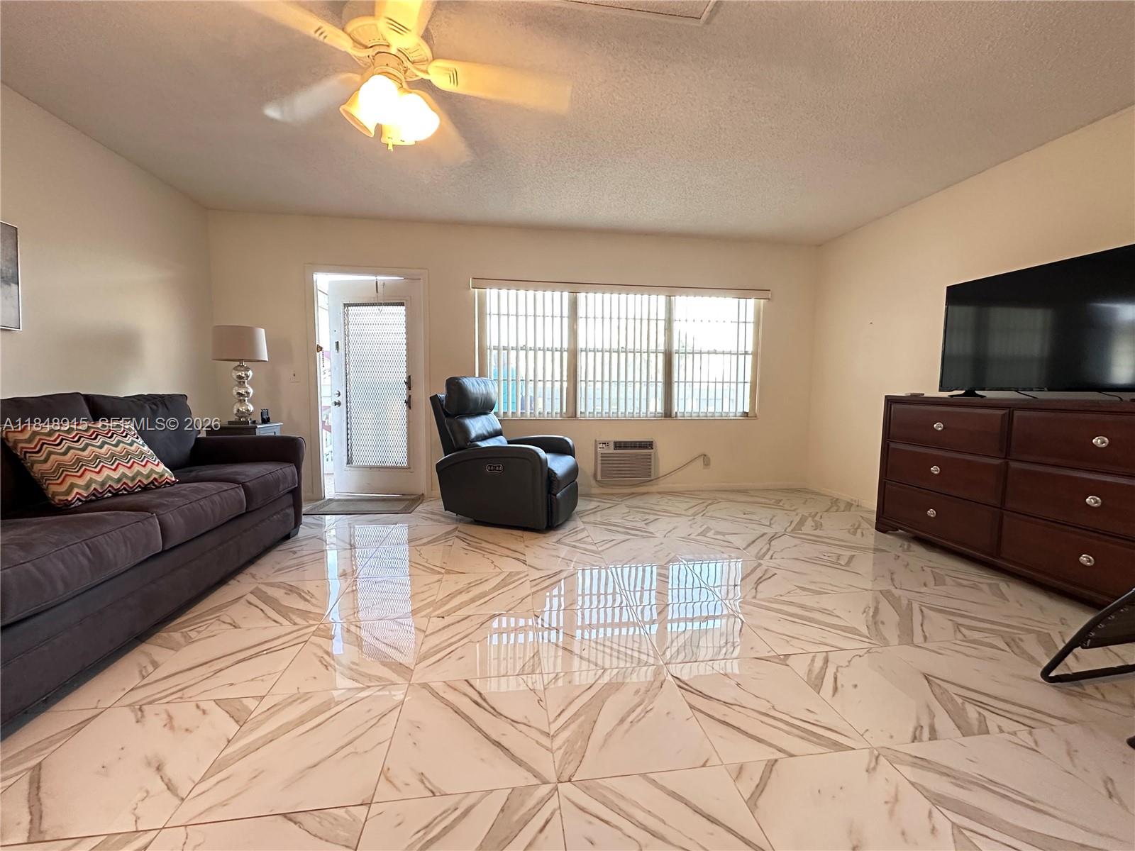 569 Fanshaw North, Unit 569 Boca Raton, FL 33434 - Photo 1 of 24 a living room with furniture and a flat screen tv