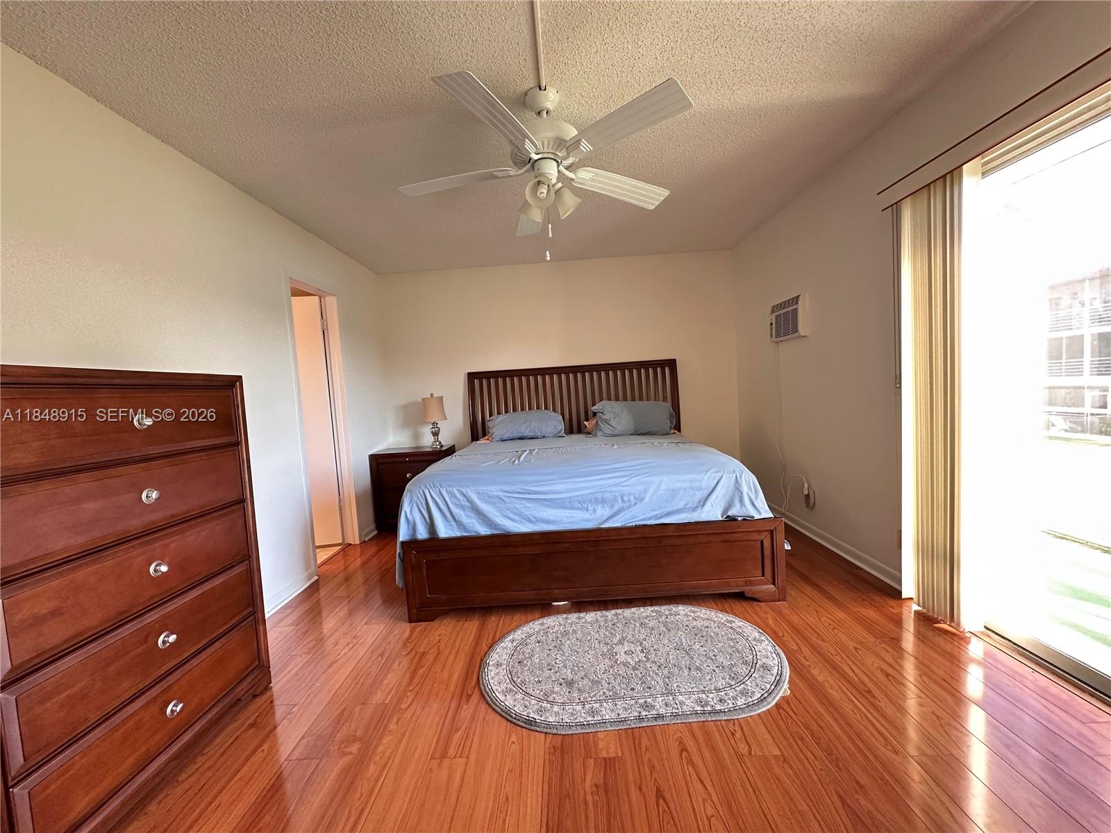 569 Fanshaw North, Unit 569 Boca Raton, FL 33434 - Photo 17 of 24 a bedroom with a bed and wooden floor