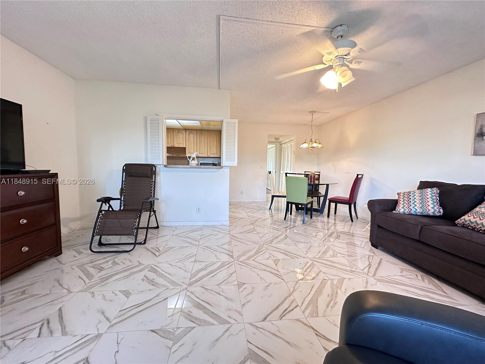 569 Fanshaw North, Unit 569 Boca Raton, FL 33434 - Photo 2 of 24 a living room with furniture and a flat screen tv