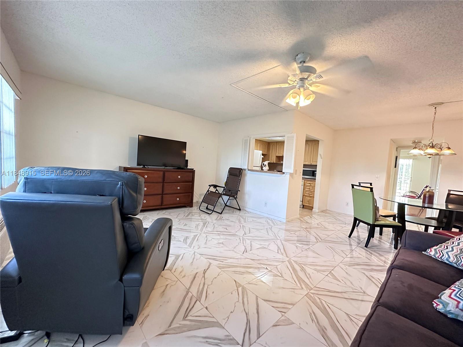 569 Fanshaw North, Unit 569 Boca Raton, FL 33434 - Photo 7 of 24 a living room with furniture and a flat screen tv