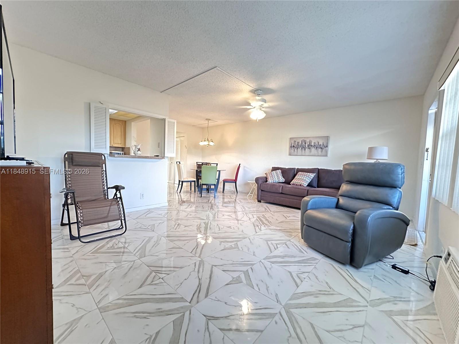 569 Fanshaw North, Unit 569 Boca Raton, FL 33434 - Photo 8 of 24 a living room with furniture and a dining table with kitchen view