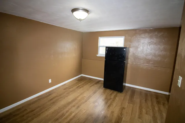 a view of empty room with wooden floor