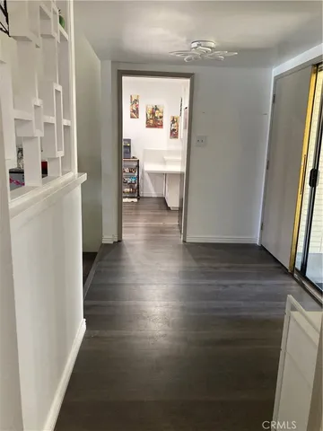 a view of a hallway with wooden floor and a living room