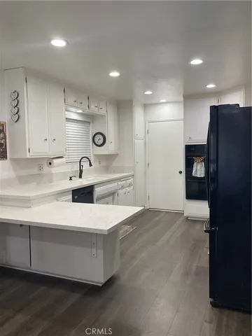 a large kitchen with stainless steel appliances a refrigerator and a sink