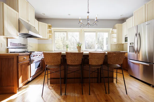 a kitchen with a dining table chairs and refrigerator