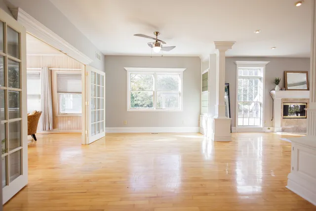 a view of an empty room with window and wooden floor