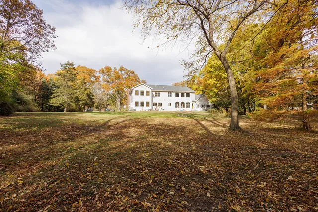 a view of street with yard and trees in the background
