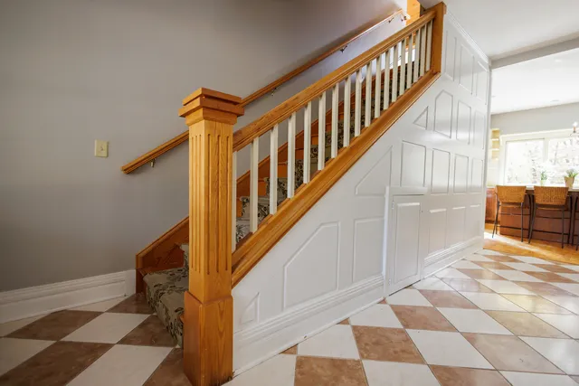 a view of staircase with white walls and a black white checkered floor