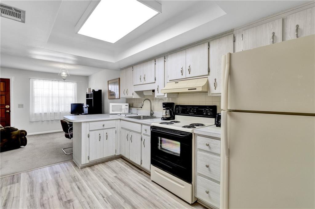 8520 Highway 1, Unit 11 Sebastian, FL 32976 - Photo 9 of 21 a kitchen with stainless steel appliances granite countertop a refrigerator a stove a sink dishwasher and white cabinets with wooden floor