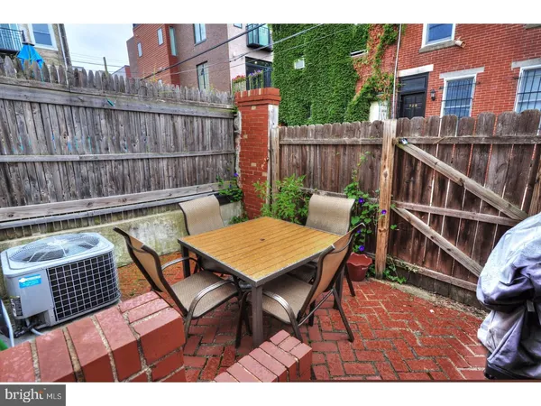 a backyard of a house with barbeque oven table and chairs