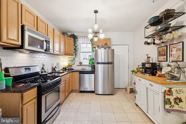 a kitchen with stainless steel appliances granite countertop a refrigerator stove and microwave