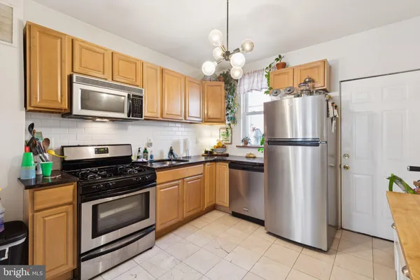 a kitchen with stainless steel appliances granite countertop a refrigerator sink stove and microwave