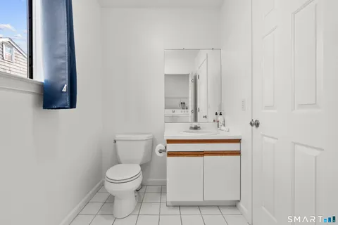 a bathroom with a toilet a sink and mirror