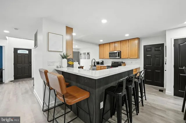 a kitchen with a dining table chairs and refrigerator