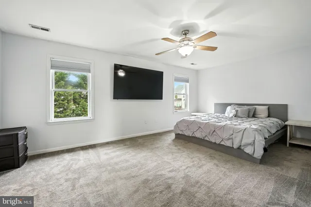 a spacious bedroom with a large bed and a flat screen tv