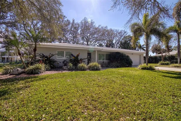 front view of house with a yard and potted plants