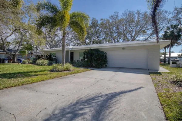 front view of a house with a yard and trees