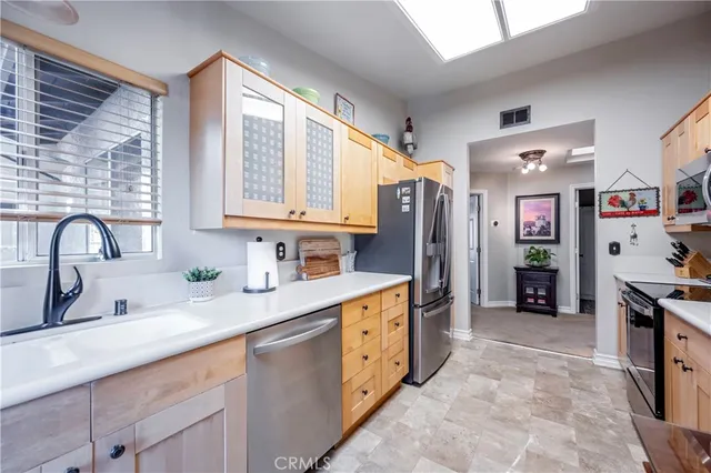 a kitchen with stainless steel appliances granite countertop a refrigerator and a sink