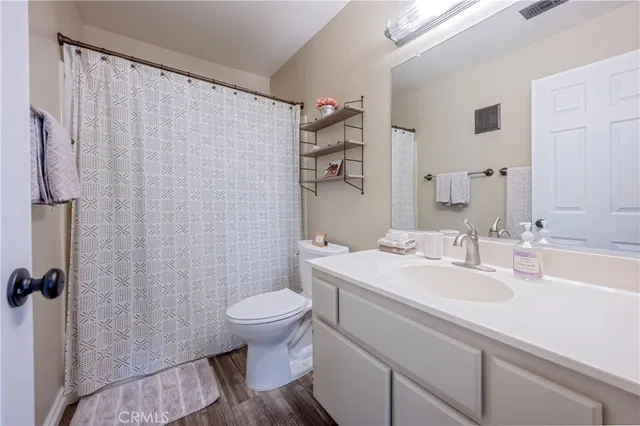 a bathroom with a sink a toilet and shower curtain
