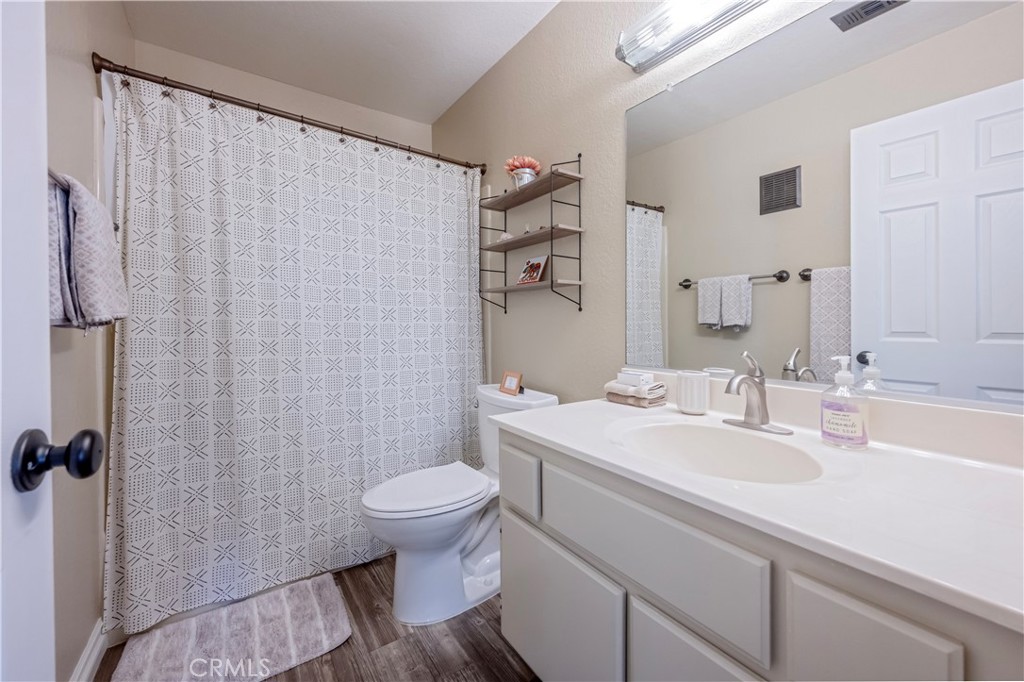 10 Corniche Drive, Unit E Dana Point, CA 92629 - Photo 19 of 25 a bathroom with a sink a toilet and shower curtain