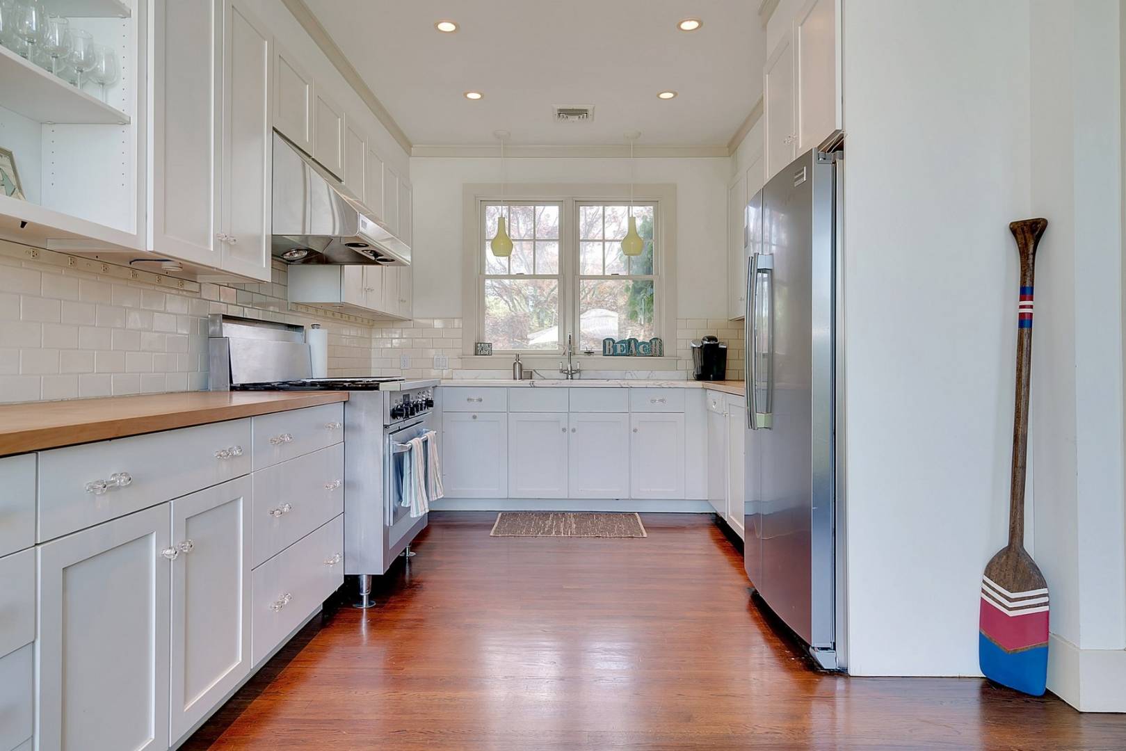 760 North Sea Mecox Road Southampton, NY 11968 - Photo 9 of 24 a kitchen with stainless steel appliances granite countertop a refrigerator a sink dishwasher and white cabinets with wooden floor