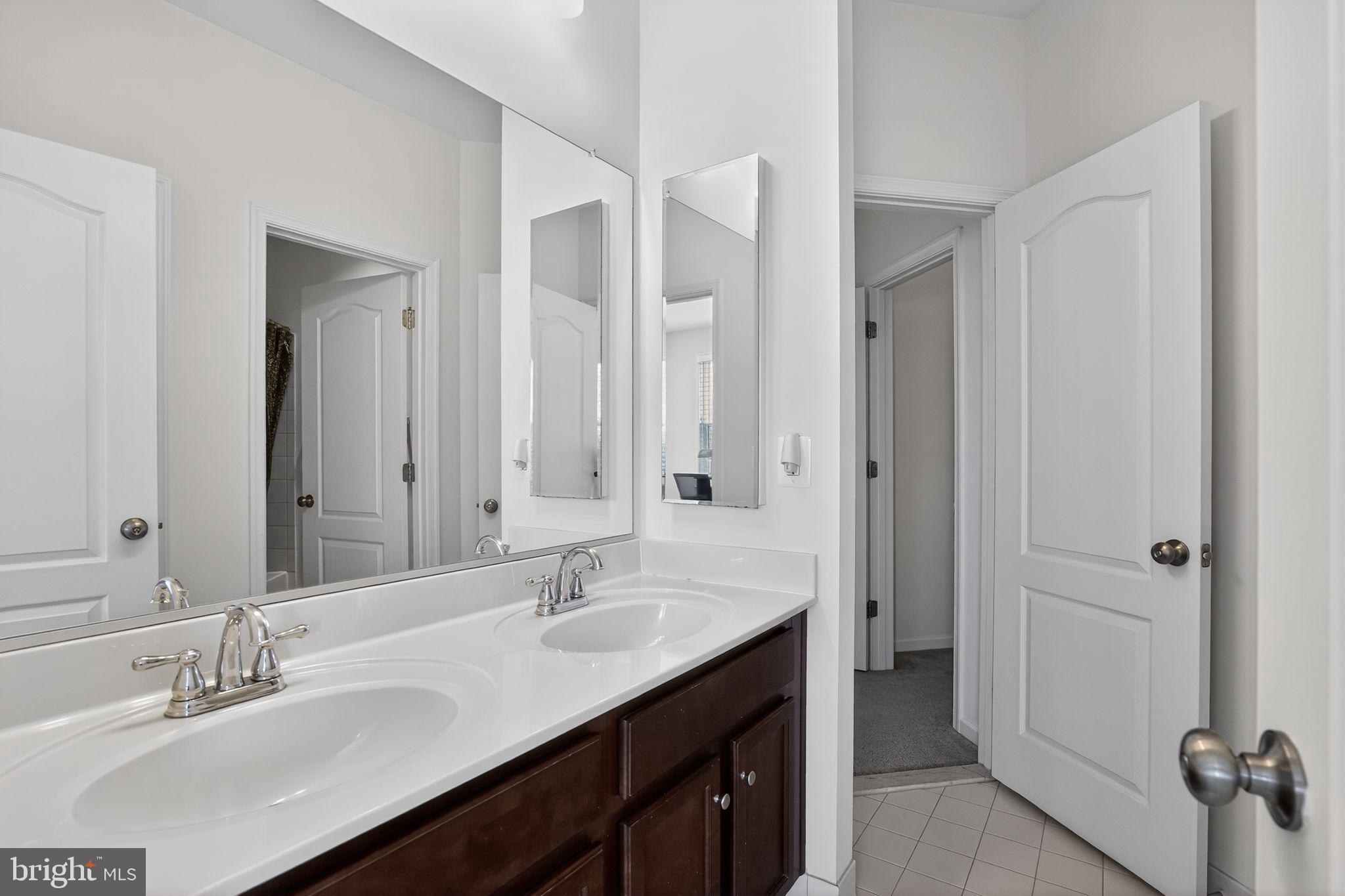 8922 Center Street Manassas, VA 20110 - Photo 13 of 24 a bathroom with double sink and a mirror