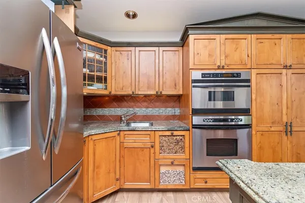 a kitchen with stainless steel appliances granite countertop a refrigerator a stove and a sink