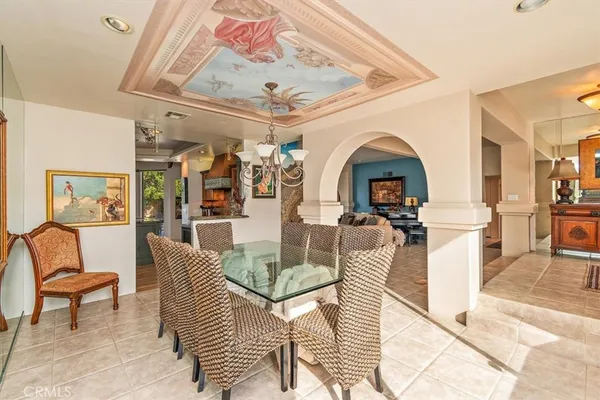 a living room with furniture a chandelier and a dining table