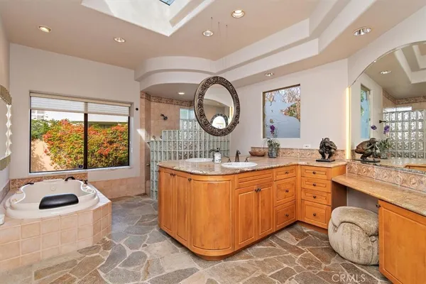 a spacious bathroom with a tub sink and mirror