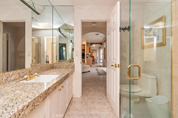 a bathroom with a granite countertop sink mirror and toilet
