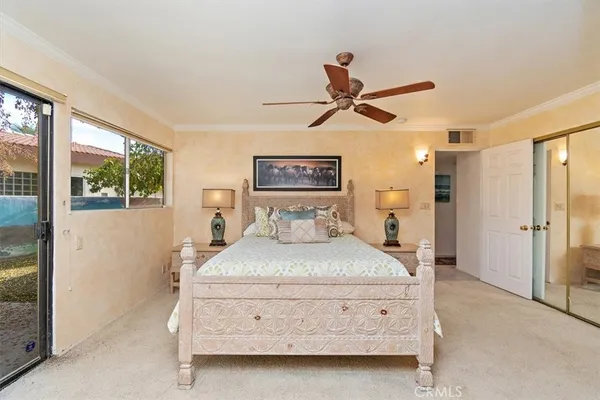 a bedroom with a bed and large mirror