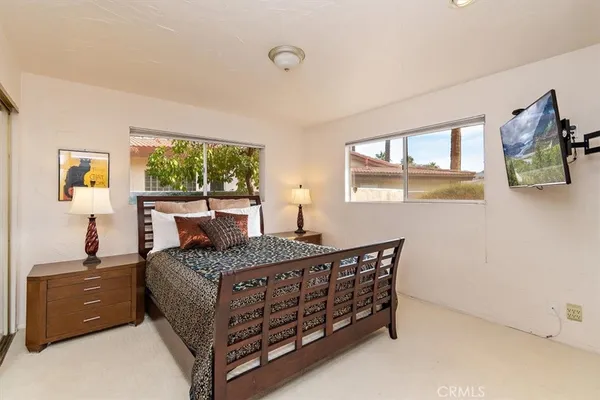 a bedroom with a bed and a dresser next to a window