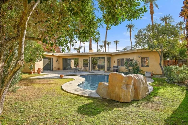 a front view of a house with swimming pool having outdoor seating