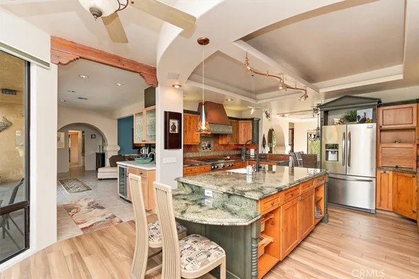a kitchen with stainless steel appliances kitchen island granite countertop a refrigerator and a sink