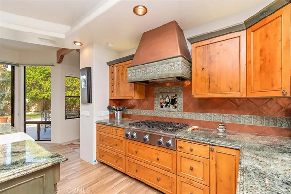 a kitchen with granite countertop wooden floors and wide window