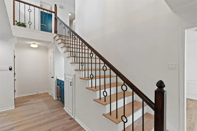 a view of staircase with wooden floor and white walls
