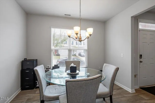 a dining room with furniture a large window and wooden floor
