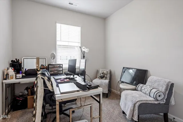 a view of a workspace with furniture and a window