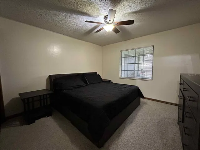 a spacious bedroom with a bed and a chandelier