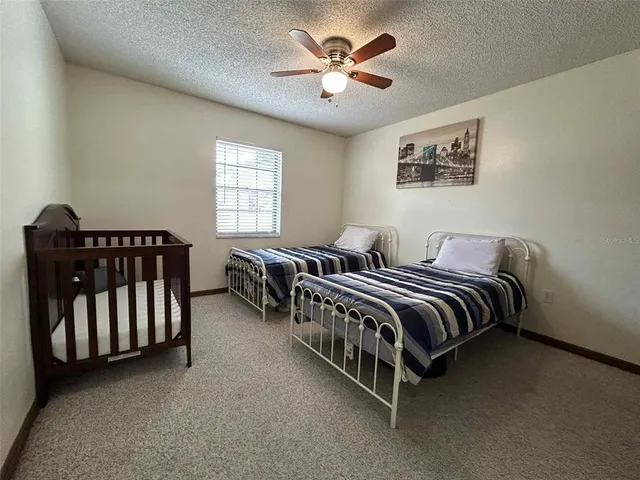 a spacious bedroom with a bed and a chandelier