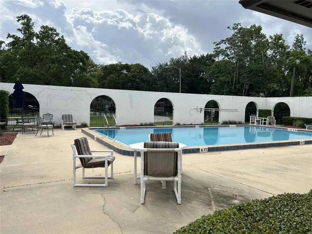 a swimming pool with outdoor seating and yard