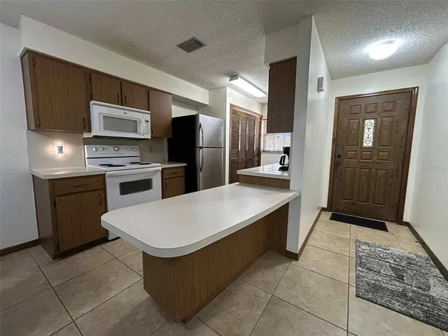 a kitchen with stainless steel appliances granite countertop a refrigerator and a stove