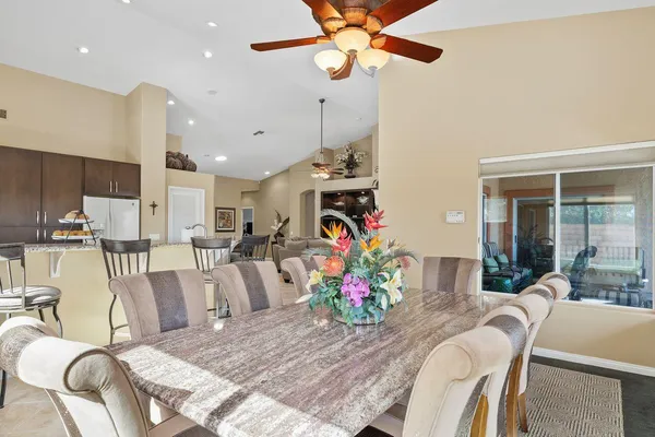 a view of a dining room with furniture a kitchen and chandelier