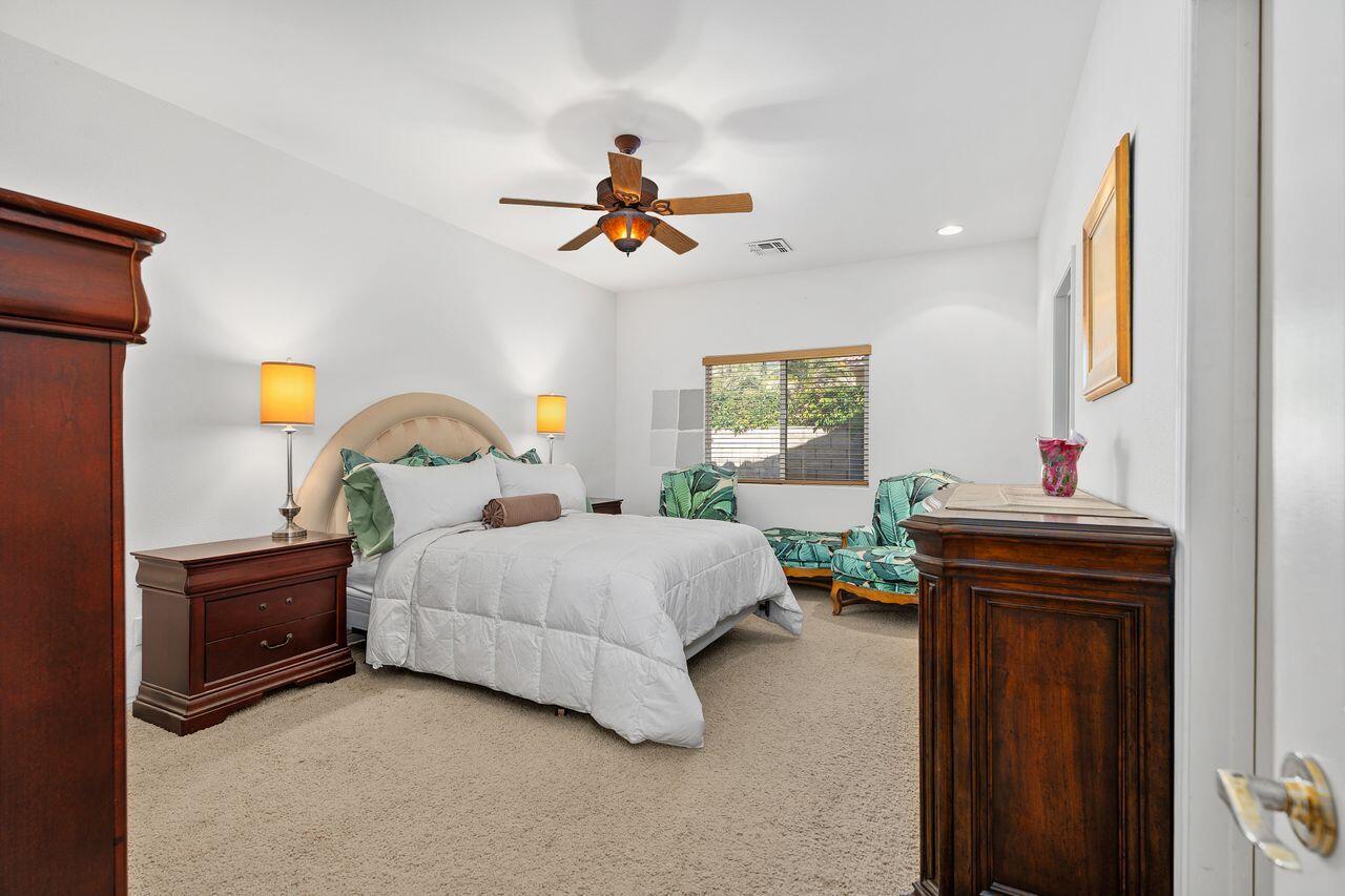 28 White Sun Way Rancho Mirage, CA 92270 - Photo 22 of 43 a bedroom with a bed and a chandelier