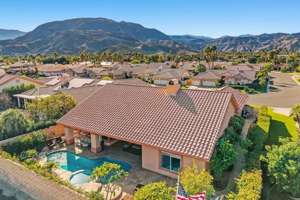 an aerial view of a house garden and mountain view in back
