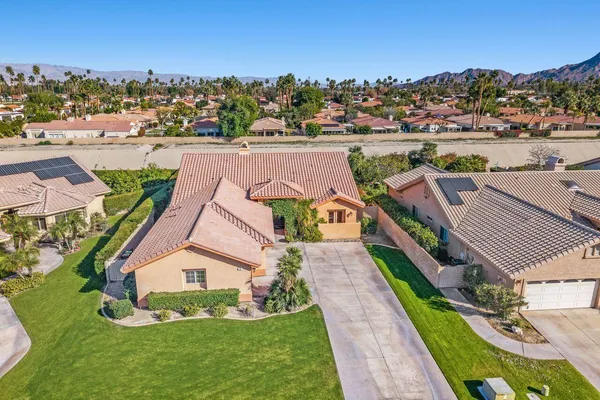 an aerial view of a house with a garden and lake view