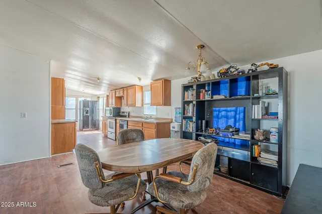 a view of a dining room with furniture and a kitchen