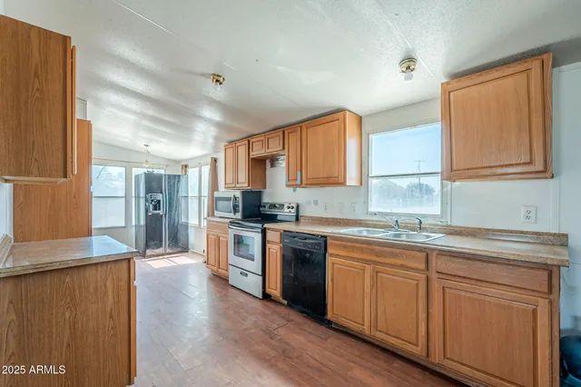 a kitchen with stainless steel appliances granite countertop a sink stove and refrigerator