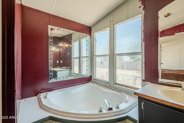 a bath room with a sink and large mirror